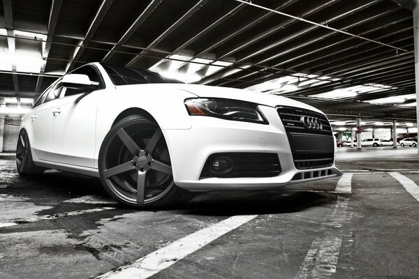 Białe Audi na parkingu podziemnym
