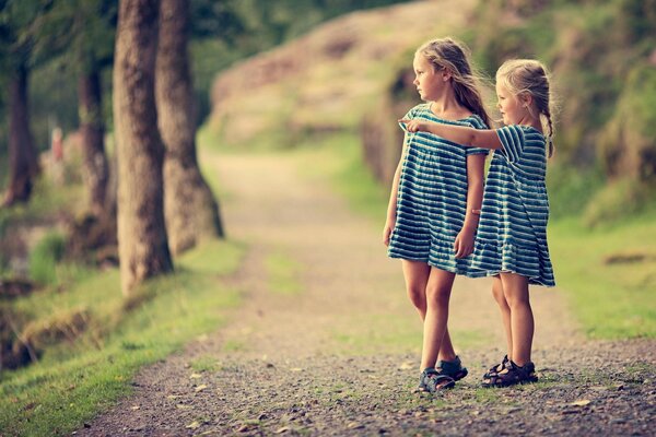 Dos chicas en la naturaleza en los mismos vestidos