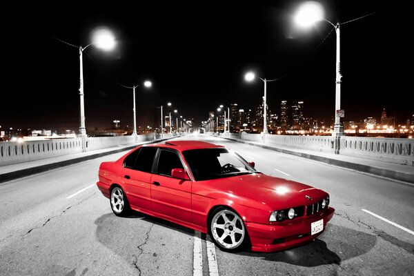 BMW rojo en la foto en blanco y negro del puente