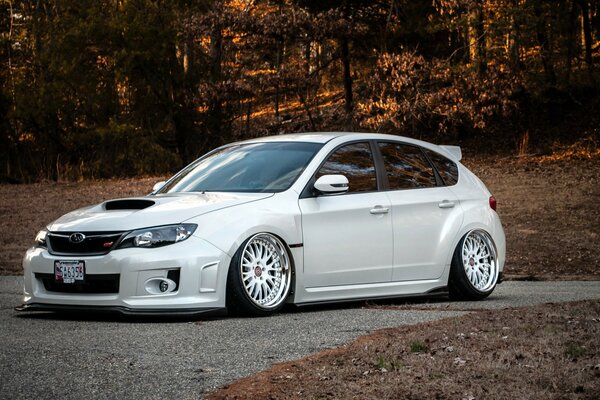 A white Japanese-made Subaru Impreza car