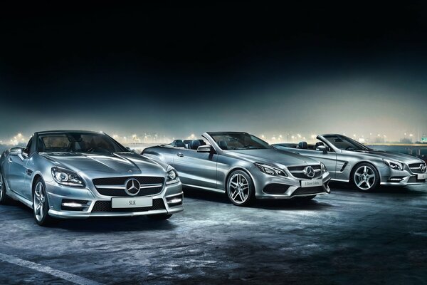 Tre convertibili Mercedes argentate su sfondo scuro