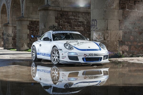 Porsche in the reflection on wet asphalt