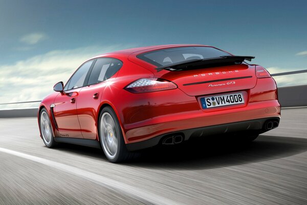 La voiture roule à grande vitesse. Porsche rouge. Voiture de sport