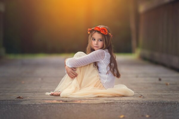 A sitting child with a crown of flowers