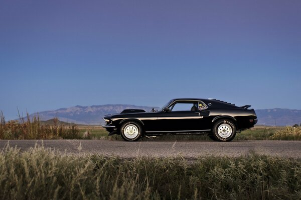 Une ford mustang noire Monte sur la route