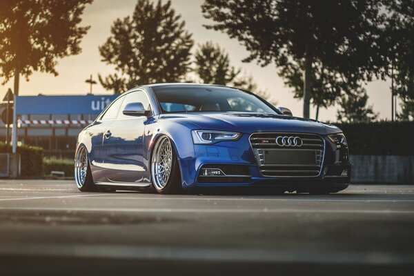 Niedriger blauer Audi s5 im Hintergrund des Sonnenuntergangs