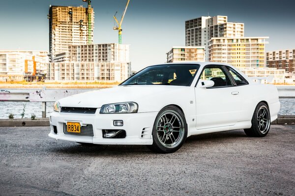 Nissan blanco como la nieve en el fondo del paisaje urbano