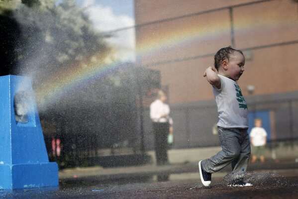 El niño se regocija con las gotas de agua