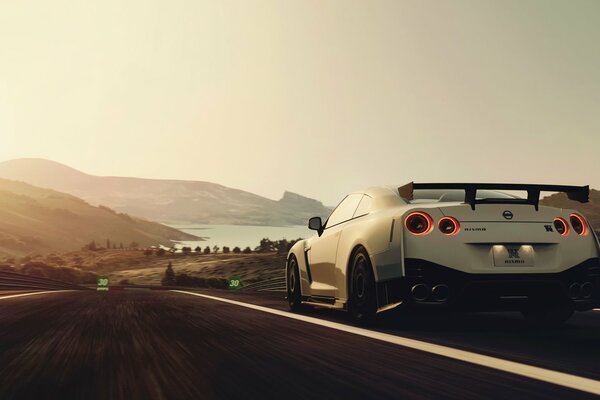 Nissan blanco conduciendo por la carretera a la velocidad en el fondo de las montañas