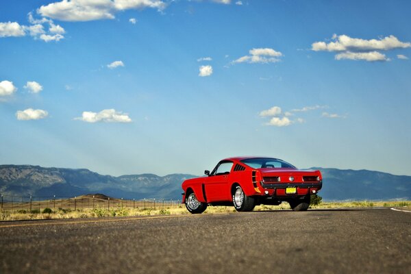 Mustang rosso Ford sulla strada del deserto