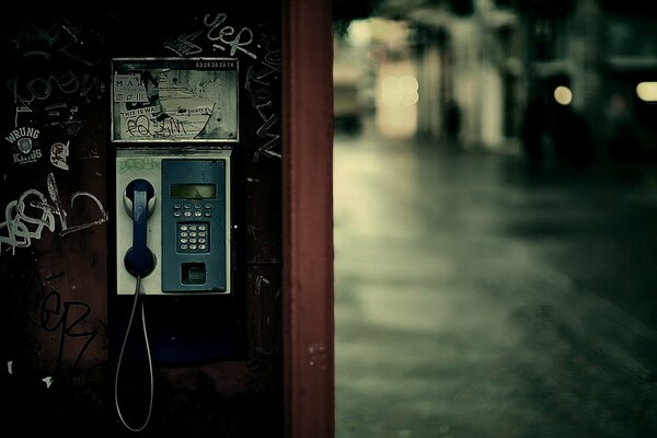 Telefonzelle inmitten einer regnerischen Stadt