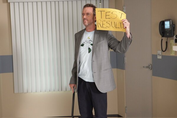 Dr. House holds a sign