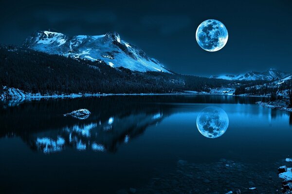 Pleine lune dans le reflet dans le lac de montagne