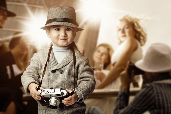 A boy with a hat and a camera in his hands