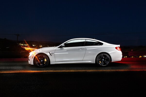Blanco BMW Coupe en el perfil de la noche