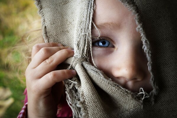 Niña Mira a través de una ranura en arpillera