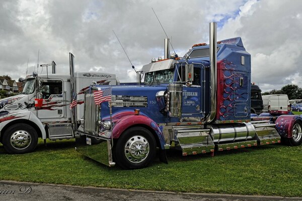 Modern trucks are parked on a green lawn