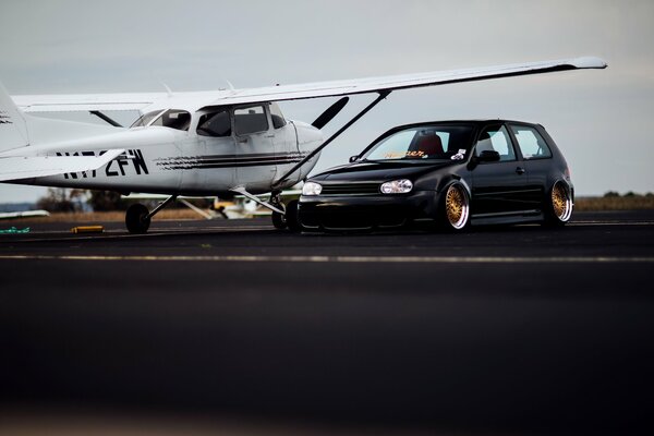 Low Volkswagen golf next to the plane