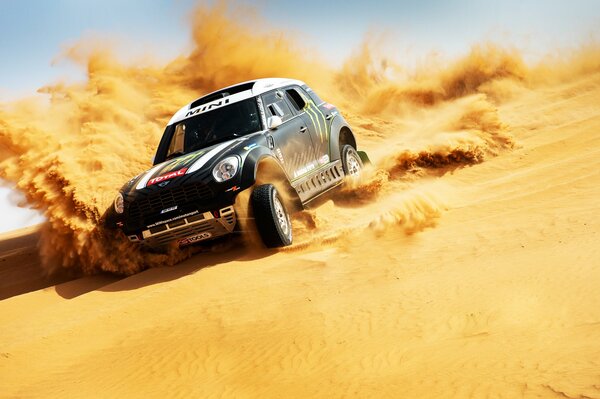Спортивная машина в пустыне едет по песку