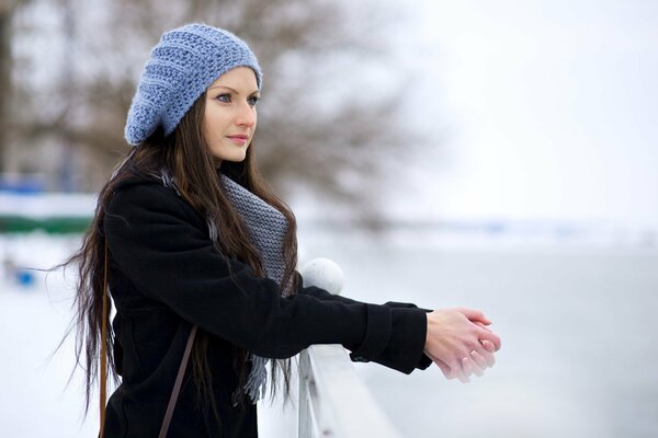 A girl in winter in a hat and scarf