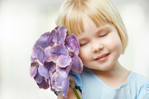 Kleines Mädchen mit Blumen auf weißem Hintergrund