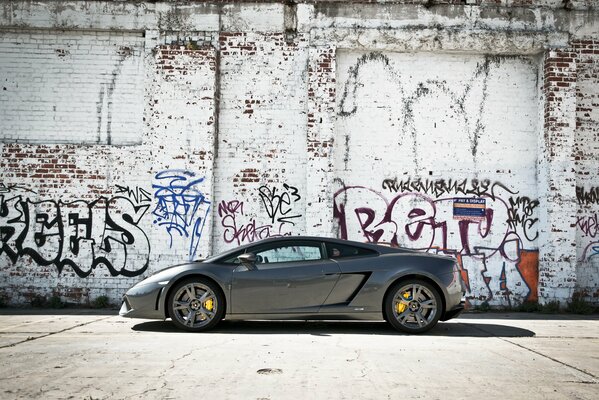Grey lamborghini gallardo car on a graffiti wall background