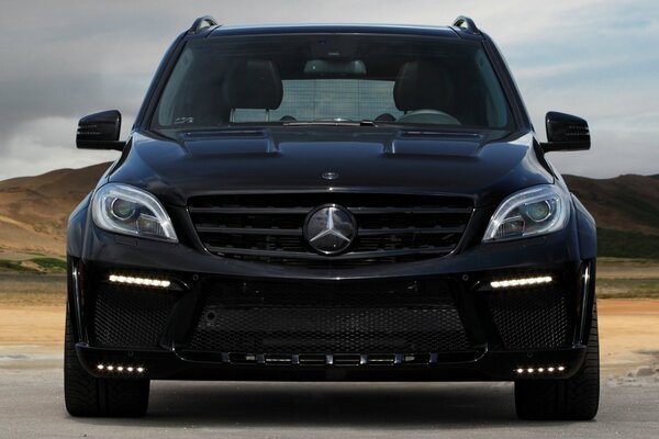 In the photo, a black Mercedes is eating on the road