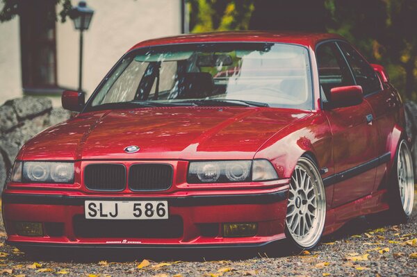 Rosso BMW E36 nel cortile in autunno