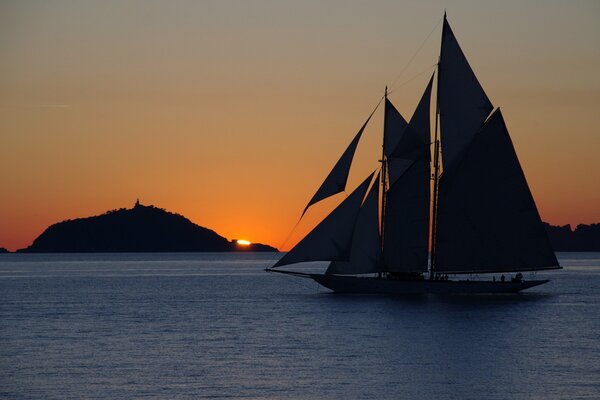 Yacht mit Segelboot bei Sonnenuntergang im Meer