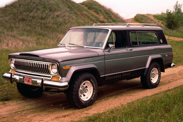 Jeep Cherokee 1976 on the background of hills