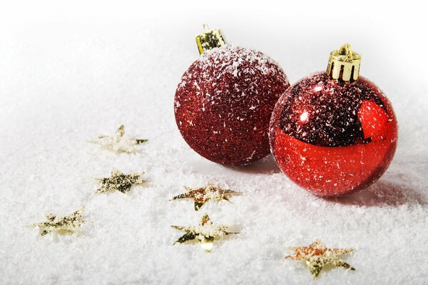 Rote Christbaumkugeln im Schnee