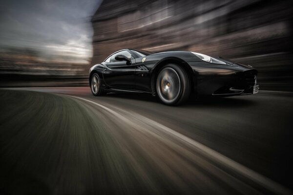 Schwarzer Ferrari California Geschwindigkeit in Bewegung mit unscharfen Hintergründen