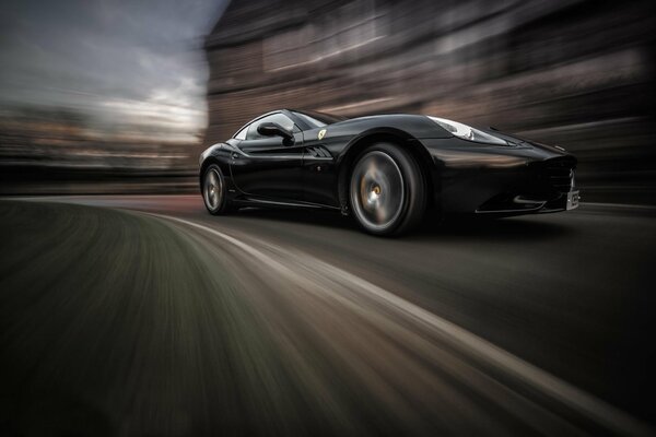 Negro Ferrari California velocidad en movimiento con fondo borroso