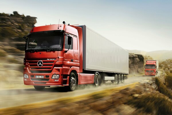 Ciężarówki z ciągnikami Mercedes pędzą po drodze z dużą prędkością