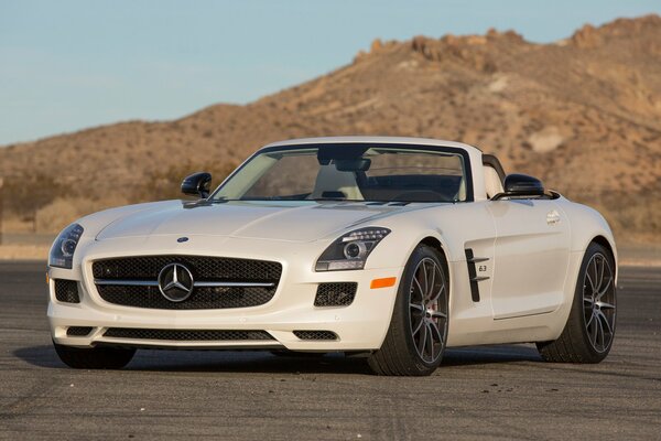 Mercedes convertible blanco con Llantas negras en el fondo de las montañas