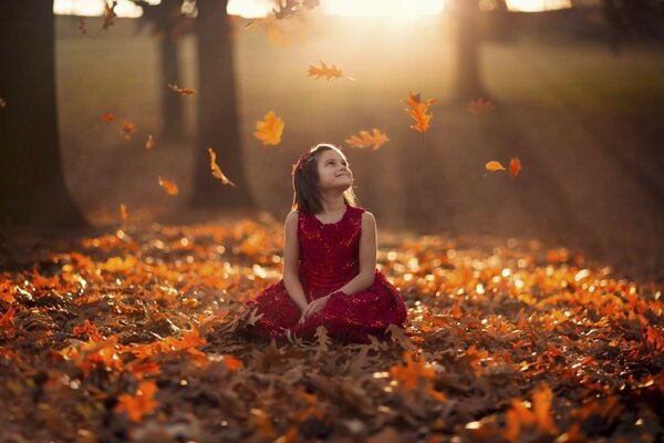 Fille dans le parc dans la poitrine de feuilles