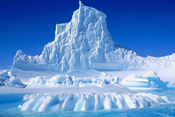 Antarktisches eisiges Ufer, mit einem eisigen Berg