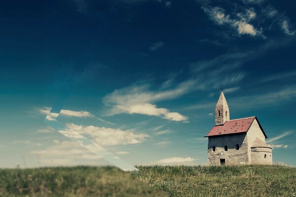 Eine einsame Kirche auf dem Rasen im Feld