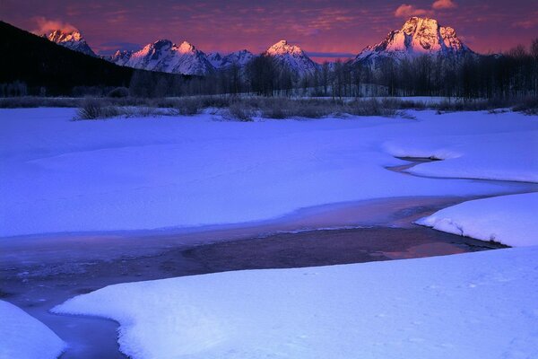 Ruisseau d hiver et quatre montagnes au loin