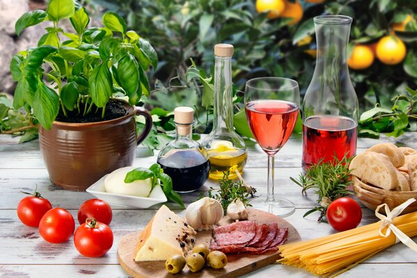 Verre de vin sur la table avec des saucisses, du fromage, des olives