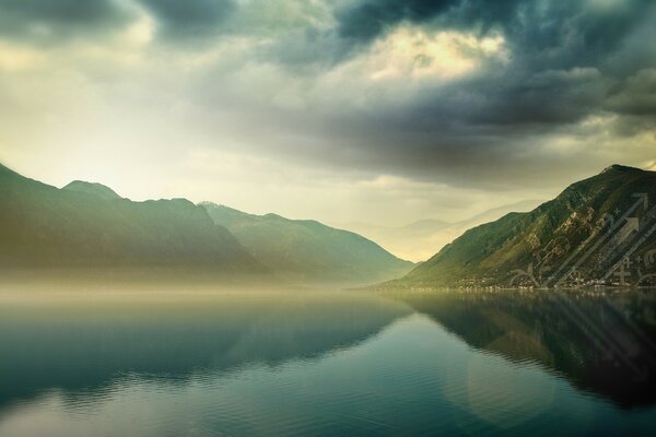 Clouds over mountains and blue lake