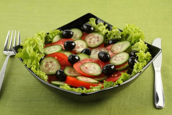 Ensalada con tomates, aceitunas y pepinos en un hermoso plato