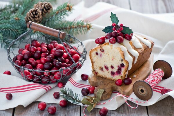 Cupcake with cranberries on the table with fir cones