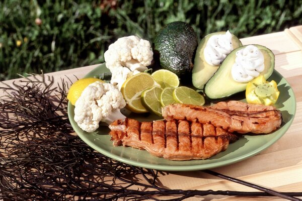 Chuleta con limón, brócoli y hierbas en un plato