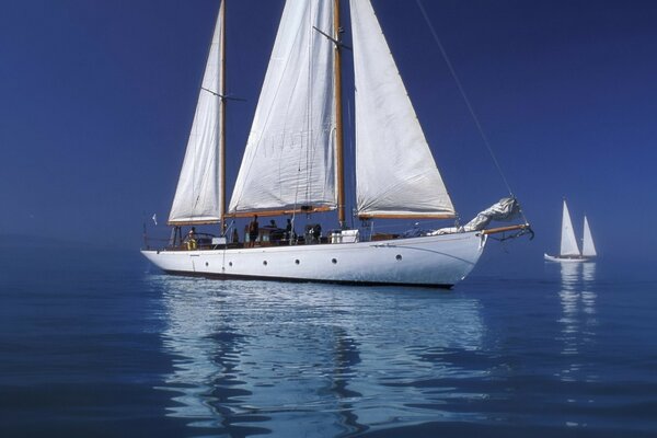 Белая яхта в море на фоне синего неба