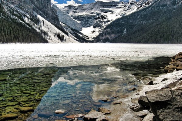 Riflessione di rocce in un lago glaciale di montagna