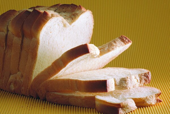 Slicing a loaf of bread on a yellow background