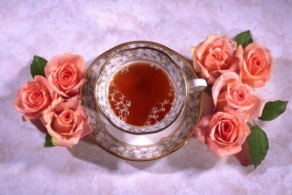 Una taza de té rodeada de rosas Rosadas