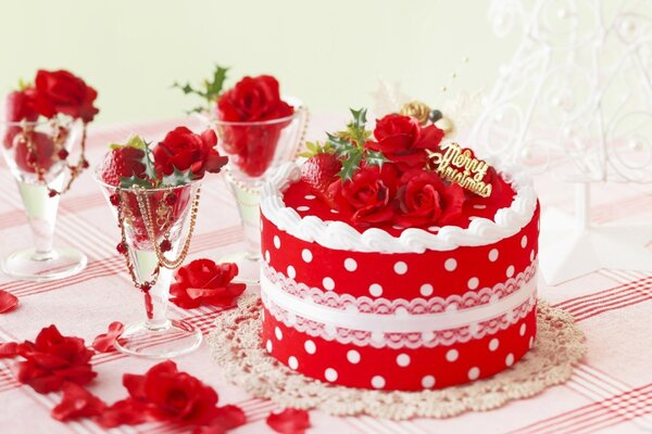 Pastel rojo con lunares blancos y copas de vino con fresas y flores