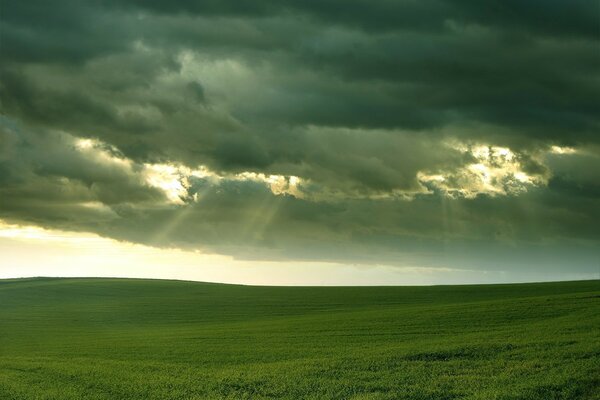 Vista del campo e raggi di sole attraverso le nuvole